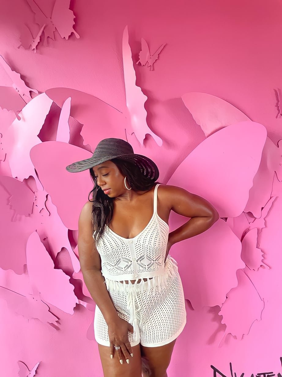 Lisa Lasley standing in front of a pink butterfly installation